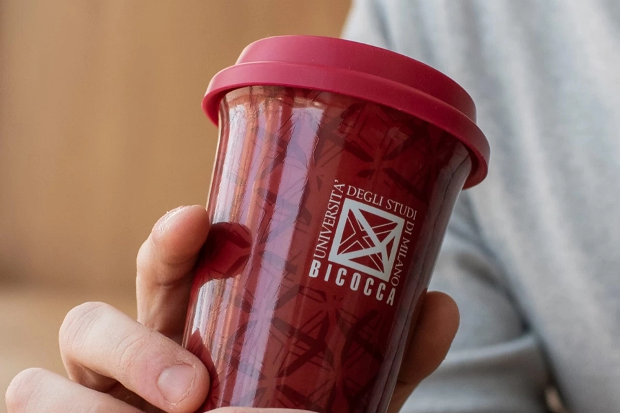 Tazza personalizzata dell’Università Milano-Bicocca prodotta da Vipitalia, tenuta in mano, parte della collezione ufficiale per studenti e personale